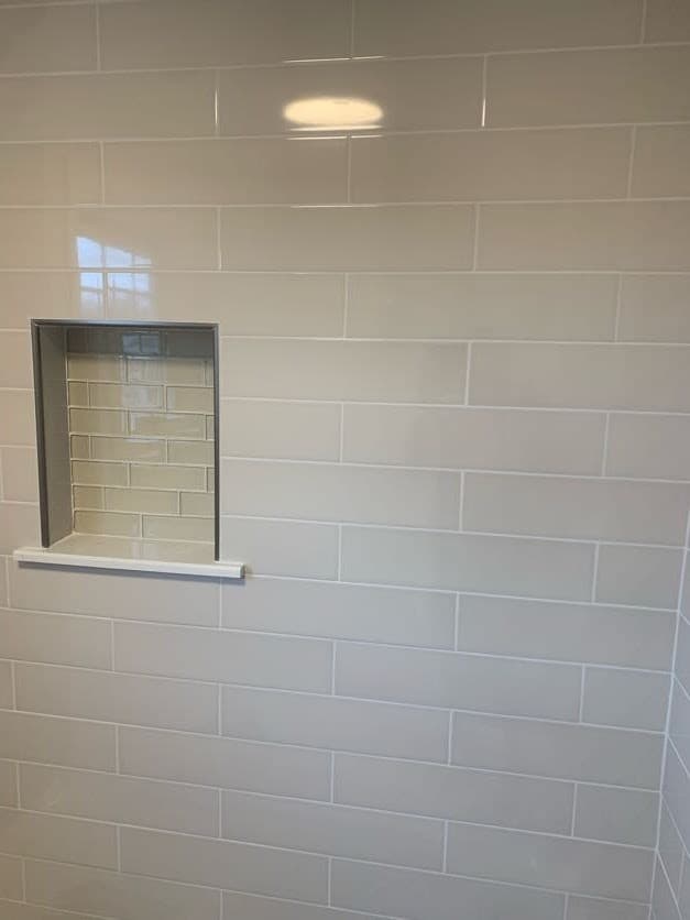 picture of a remodeled bathroom wall with clean white tiles