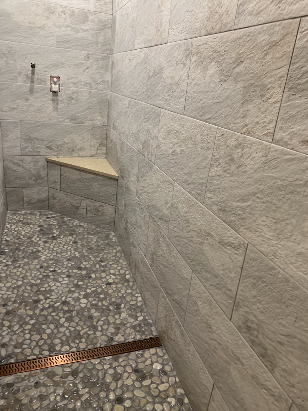 picture of a newly remodeled bathroom with textured beige tile floors and walls